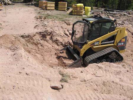 04-Brown Duck Lake Stabilizatoin, skid steer begins cutting breach through Dam after riprap was removed