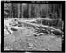 HAER photo of Deer Lake Dam showing upstream face with spillway in foreground, July 1985