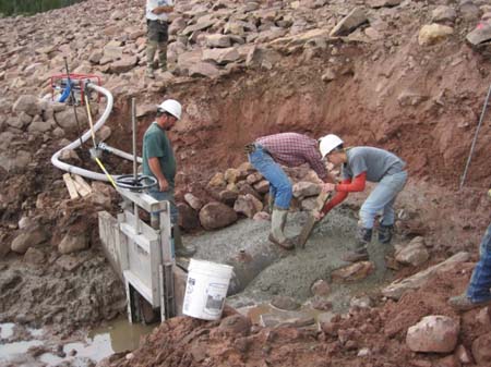 10-East Timothy Stabilization, crew batch and pour cement on new head structure on existing outlet pipe