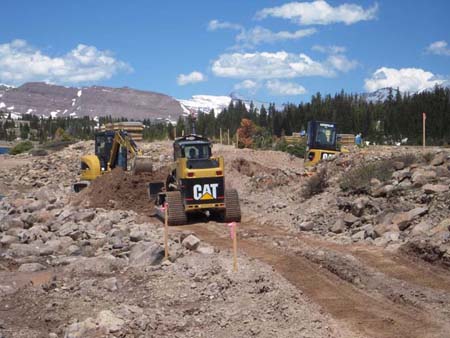 07-Five Point Lake Stabilization, skidsteer and trackhoe make cut in dam