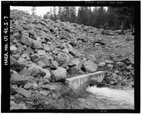 HAER photo of downstream face and toe of Island Lake Dam with outlet pipe and concrete collar, July 1985