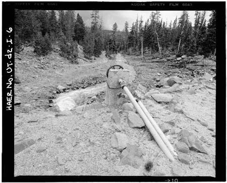 HAER photo of outlet gate wheel and stem with outlet channel in background at Island Lake Dam, July 1985