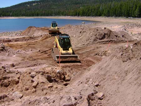 04-Kidney Lake Stabilization, skid steer begins cutting breach through dam